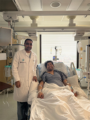 A doctor standing next to their patient in a hospital bed