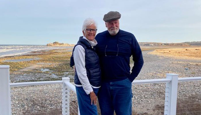 An older couple standing by a beach