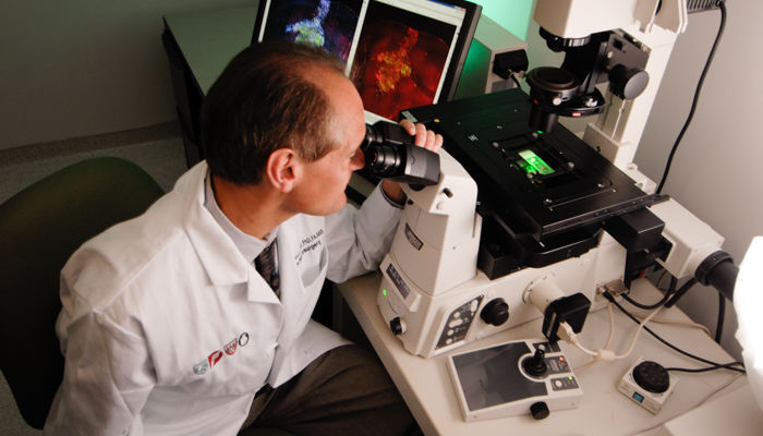 researcher at a microscope